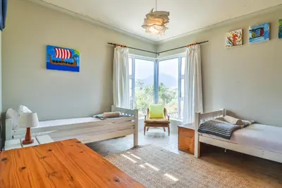 a living room with two beds and a window at Mountain View in Bettyʼs Bay