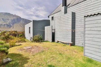 a white building with a bench next to it at Mountain View in Bettyʼs Bay