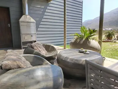 a patio with three large metal ottomans and a grill at Mountain View in Bettyʼs Bay