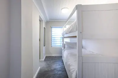 a bedroom with two bunk beds and a window at Beautiful family beach cottage! in Pringle Bay