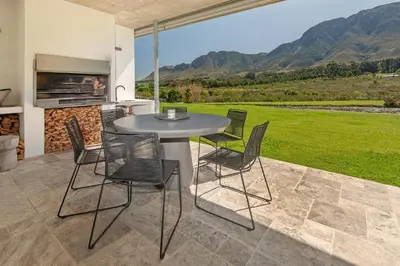 a table and chairs on a patio with a view at Villetta in Mosselrivier