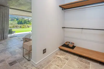 a bedroom with a bed and a table and a window at Villetta in Mosselrivier