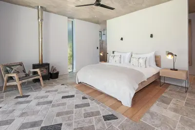 a bedroom with a large bed and a fireplace at Villetta in Mosselrivier