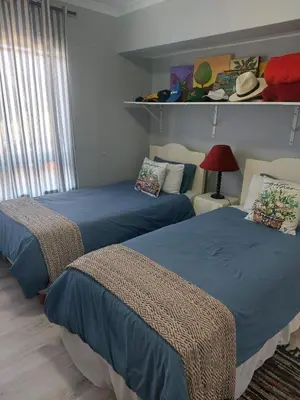 a bedroom with two beds and a red lamp at Self-Catering Apartment near beach in Strand