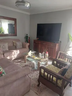 a living room with couches and a flat screen tv at Self-Catering Apartment near beach in Strand