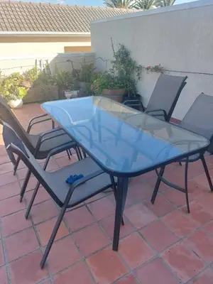 a glass table and chairs on a patio at Self-Catering Apartment near beach in Strand