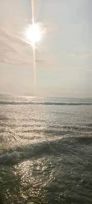 a sun shining over the ocean on a beach at Self-Catering Apartment near beach in Strand