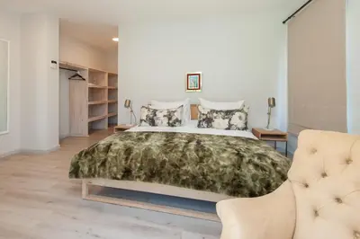 a bedroom with a large bed and a couch at Casa La Vita in Hermanus