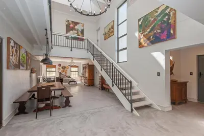 a living room with a staircase and a dining room at Casa La Vita in Hermanus