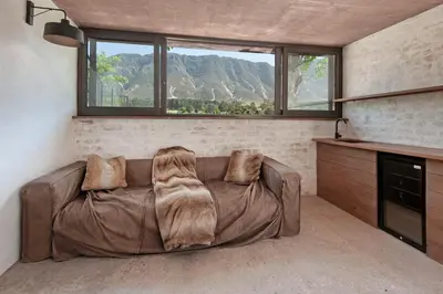 a brown couch in a living room with a window at Casa La Vita in Hermanus