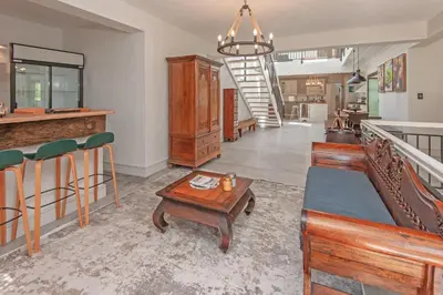 a living room with a table and chairs and a staircase at Casa La Vita in Hermanus