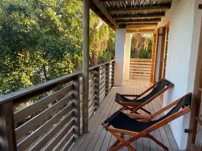 two chairs sitting on the porch of a house at Sunset Beach Studio Apartment in Cape Town