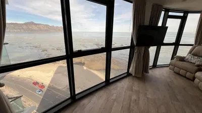 a room with a view of the ocean from a window at Ocean View 1004 Luxury Backup Power in Strand