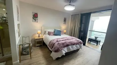 a bedroom with a bed and a window with a view at Ocean View 1004 Luxury Backup Power in Strand