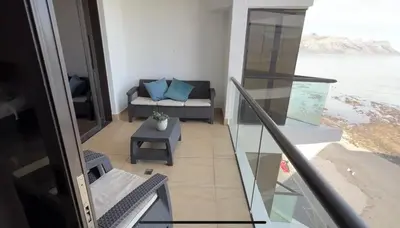 a room with a balcony with a couch and a table at Ocean View 1004 Luxury Backup Power in Strand
