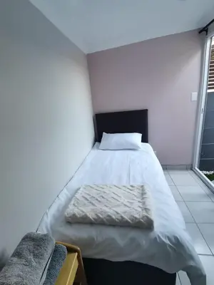 a large bed in a room with two windows at Cozy Business overnighter in Bellville