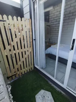 a balcony with a bed and a sliding glass door at Cozy Business overnighter in Bellville