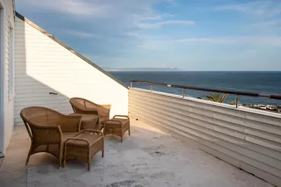 a balcony with chairs and a view of the ocean at Hermanus Luxury Penthouse in Hermanus