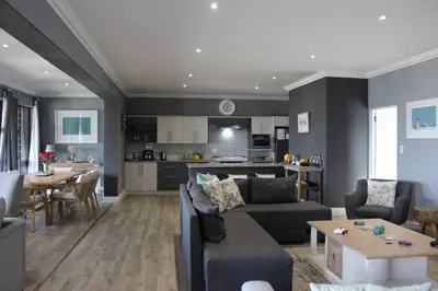 a living room with a couch and a table and a kitchen at 17 Suikerbossie in Hermanus