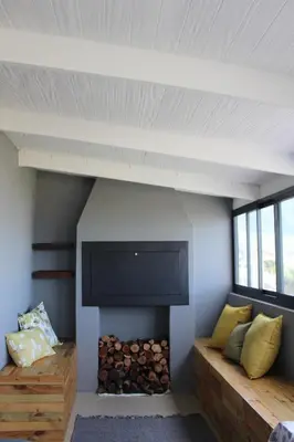 a room with a fireplace with a tv and a couch at 17 Suikerbossie in Hermanus