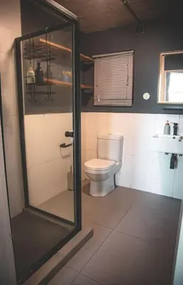 a bathroom with a toilet and a glass shower at Kape Loft in Cape Town