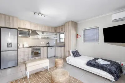 a living room with a couch and a kitchen at Mayfair 246 by Host Agents in Cape Town