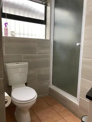 a bathroom with a toilet and a window at The High Street Accommodation in Durbanville
