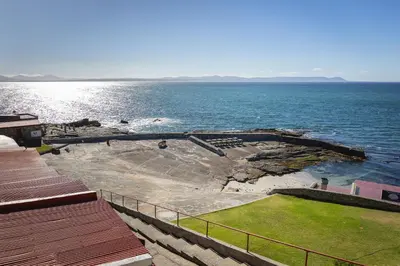 a view of the ocean with a rock in the water at Sea-View Studio - Hermanus Waterfront Apartments in Hermanus