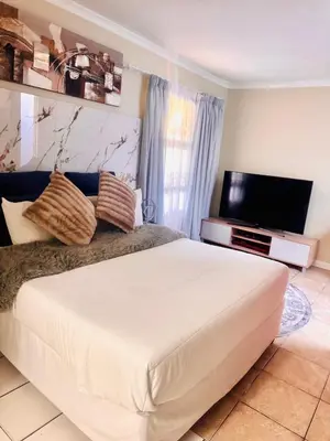 a bedroom with a large bed and a flat screen tv at Greens Haven, Your Private escape in Cape Town in Cape Town
