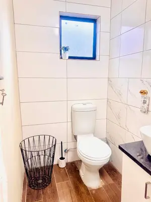 a bathroom with a toilet and a window at Greens Haven, Your Private escape in Cape Town in Cape Town