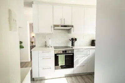 a white kitchen with white cabinets and a stove at Coastal Living in Hermanus
