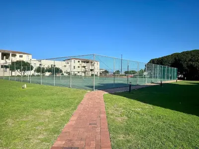 a tennis court with a chain link fence at Coastal Living in Hermanus
