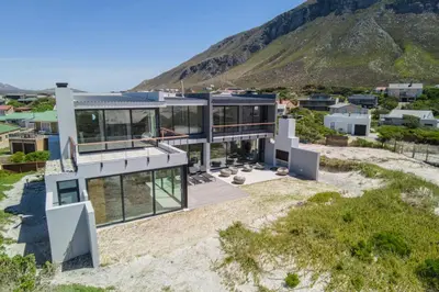 an aerial view of a house with mountains in the background at The Dunes in Bettyʼs Bay