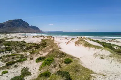 an aerial view of a sandy beach with the ocean at The Dunes in Bettyʼs Bay