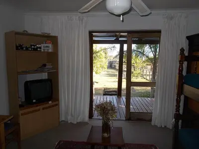 a living room with a television and a sliding glass door at Erf 473 Fisherhaven in Fisherhaven