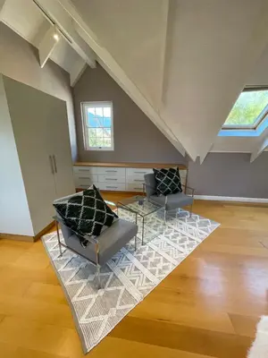 a living room with two chairs and a glass table at Franschhoek Manor in Franschhoek
