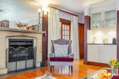 a living room with a chair and a fireplace at Franschhoek Manor in Franschhoek