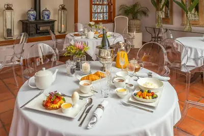 a white table with plates of food on it at Franschhoek Manor in Franschhoek