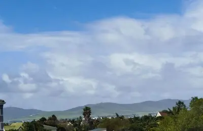 a cloudy sky with mountains in the background at Affordable Luxury in Cape Town