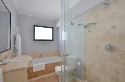 a bathroom with a toilet and a sink and a shower at Church View Lux Apartment in Stellenbosch