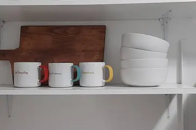 a shelf with four coffee mugs on it at Convenient Comfort in Cape Town