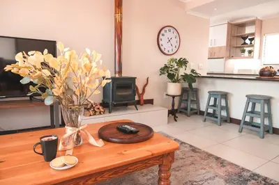a living room with a table with a vase of flowers at Hermanus Reefs in Hermanus