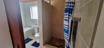 a bathroom with a toilet and a sink and a shower at 4859 Lakeside in Bettyʼs Bay