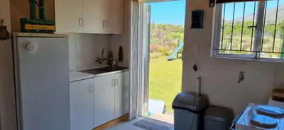 a kitchen with a white refrigerator and a window at 4859 Lakeside in Bettyʼs Bay