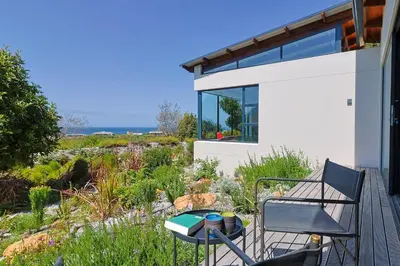 a patio with a table and chairs on a deck at BonAir Betty's Bay in Bettyʼs Bay