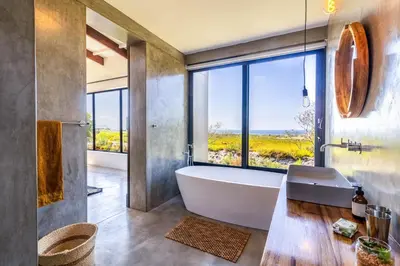 a bathroom with a tub and a large window at BonAir Betty's Bay in Bettyʼs Bay