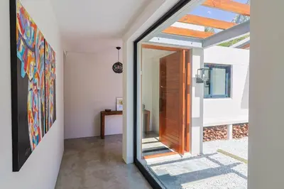 a pivot door in a house with a glass doorway at BonAir Betty's Bay in Bettyʼs Bay