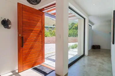 a wooden door in a room with a sliding glass door at BonAir Betty's Bay in Bettyʼs Bay