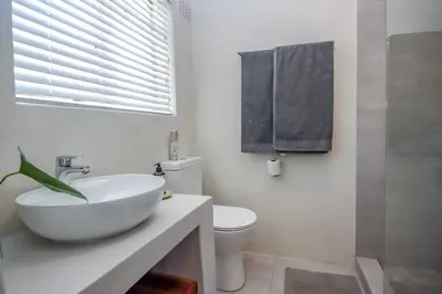 a white bathroom with a sink and a toilet at #Spacious Cozy Stay- Free parking in Stellenbosch