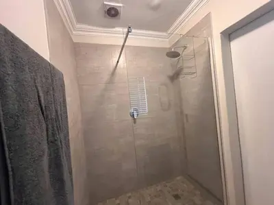 a shower with a glass door in a bathroom at #Spacious Cozy Stay- Free parking in Stellenbosch